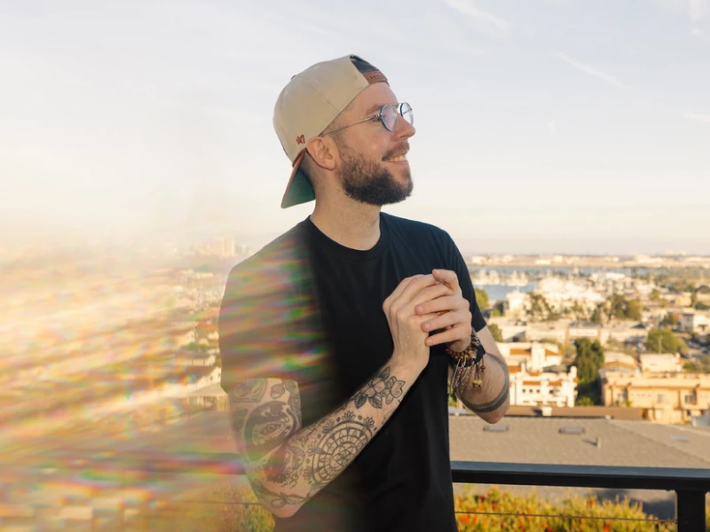 Jake smiling on a balcony overlooking the marina at golden hour