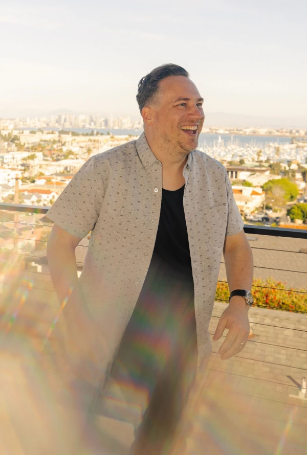 A Ballpark teammate laughing on a balcony overlooking the city harbor