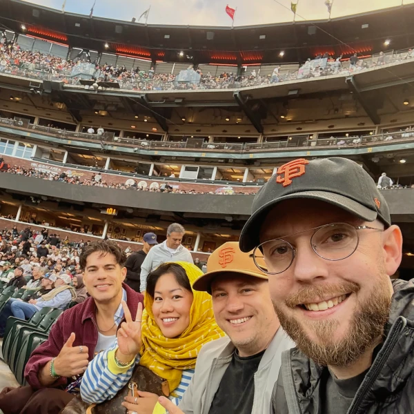 Ballpark teammates smiling in the stands at a baseball game